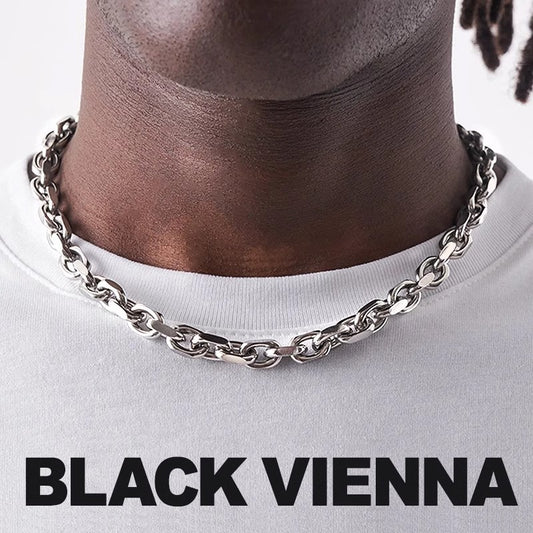 Silver chain necklace on a person wearing a white shirt with 'BLACK VIENNA' text.