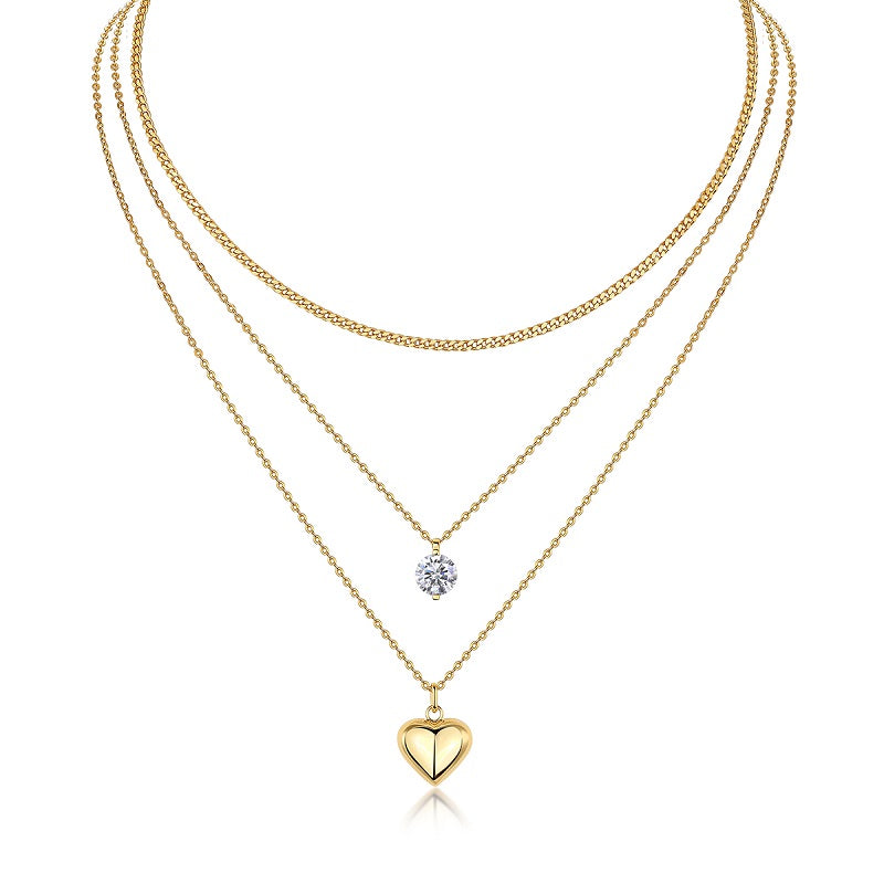 Three gold necklaces with heart and round pendants on a white background