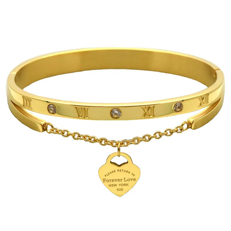A gold-colored stainless steel bracelet with rhinestone accents and a charm that reads 'Forever Love New York'.