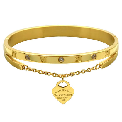 A gold-colored stainless steel bracelet with rhinestone accents and a charm that reads 'Forever Love New York'.