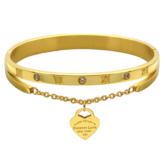 A gold-colored stainless steel bracelet with rhinestone accents and a charm that reads 'Forever Love New York'.
